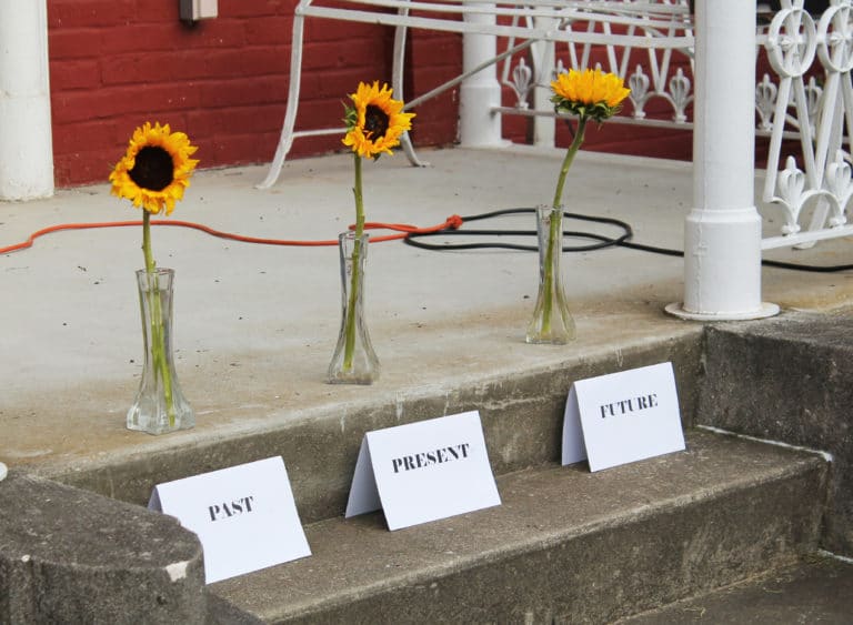 The sunflowers were placed behind these “past, present and future” signs on the original steps.