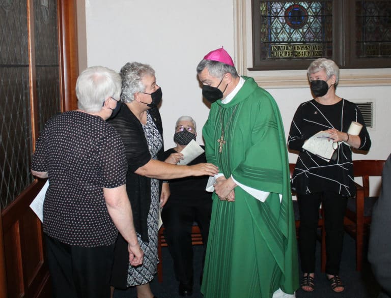Sister Martha Keller, second from left, the incoming assistant congregational leader, says something to Bishop William Medley before the installation that made both of them laugh. At left is Sister Suzanne Sims, seated in the center is Sister Ann McGrew, an incoming councilor, and at right is Sister Pam Mueller, who was leaving office as a councilor.