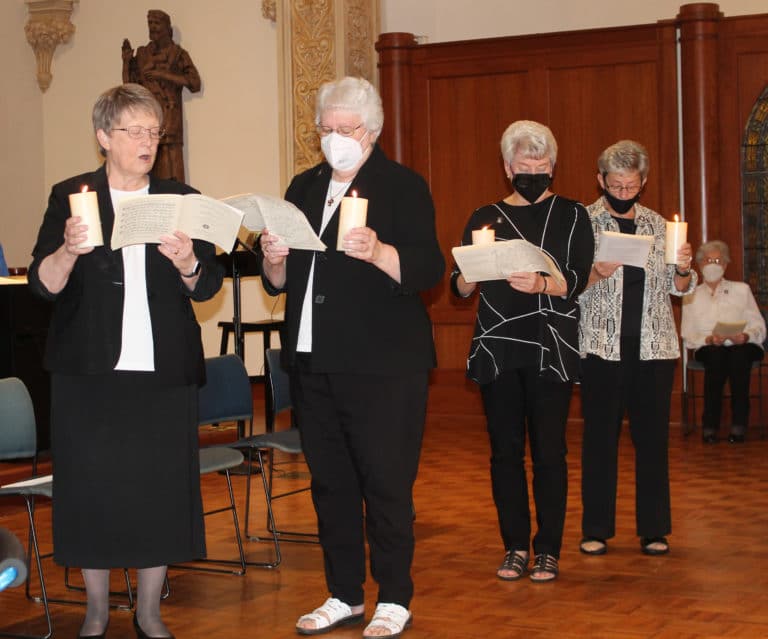The outgoing Leadership Council members hold candles lighted from the Paschal Candle and read the words of Saint Angela Merici as they prepared to pass on their light to the incoming Council. From left are Sister Amelia Stenger, Sister Pat Lynch, Sister Pam Mueller and Sister Judith Nell Riney.