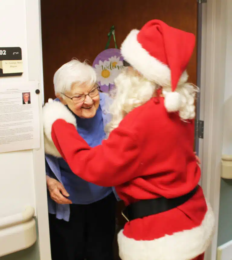 Sister George Mary Hagan is all smiles as she gets a hug from Santa Claus.