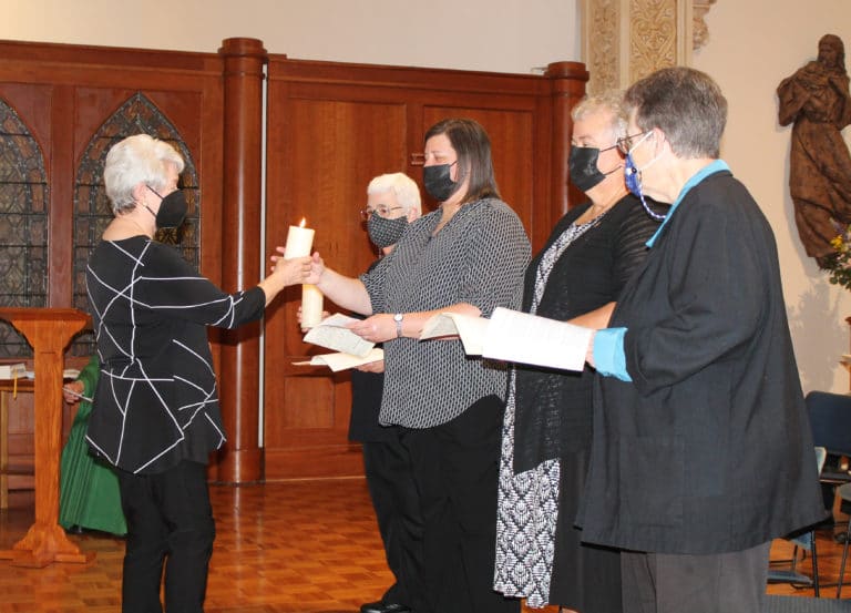 Each member of the outgoing Council passed their candle to their counterpart on the new Council, saying “I share with you the light of the Spirit and pray God’s blessing upon you.” Here, Sister Pam Mueller hands her candle to Sister Monica Seaton.