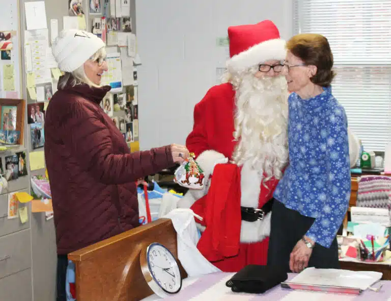 Sister Claudia Hayden enjoys her visit from Santa and Mary Ann Willett.