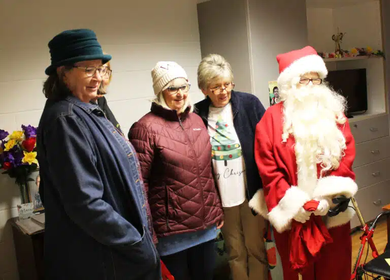 1972 alumnae pose for a photo for Sister Grace Simpson. From left are Carm Leonard, Dorothy Riggs (mostly hidden), Mary Ann Willett, Rita Tanner and Santa Claus.