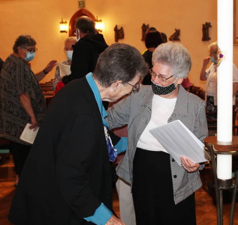 Sister Nancy Murphy, right, congratulates Sister Sharon Sullivan after Mass. The two served together on the Council from 2010-16.
