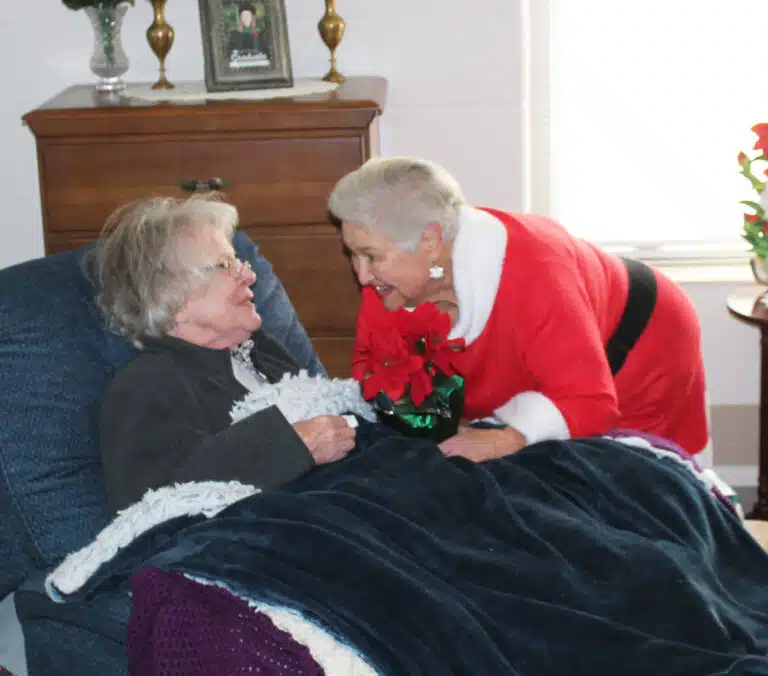 Elaine Wood hands a poinsettia to Sister Catherine Barber. Elaine Wood hands a poinsettia to Sister Catherine Barber.