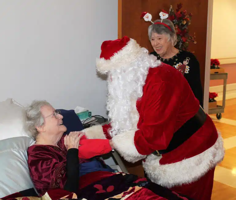 Sister Pat Rhoten looks at Santa like she has all of her life, as Associate Sid Mason looks on.