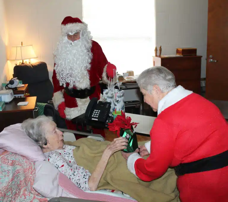 Sister Grace Swift is grateful to receive a poinsettia and other gifts from Santa and Mrs. Claus. Sister Grace Swift is grateful to receive a poinsettia and other gifts from Santa and Mrs. Claus.