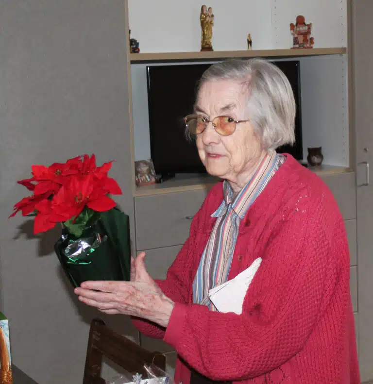 Sister Mary Gerald Payne looks for a place where she can enjoy her new poinsettia. Sister Mary Gerald Payne looks for a place where she can enjoy her new poinsettia.