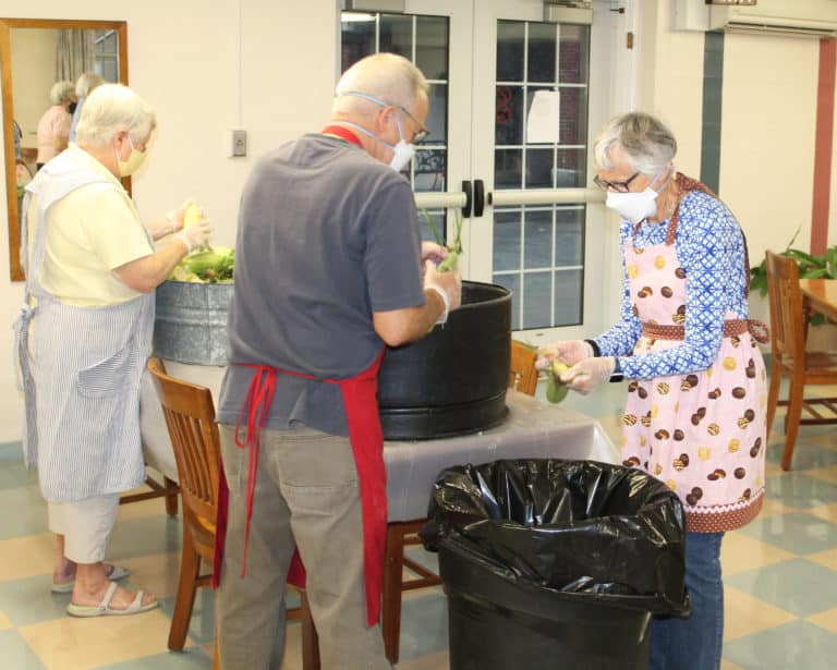 Carolyn McCarty, right, who became an Ursuline Associate in June, is joined by her husband, John, as Sister Suzanne Sims works at left.