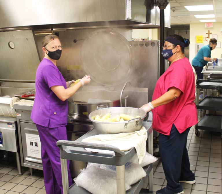 Melody Payne, left, food service manager, and employee Tina Jackson count the ears of corn before placing them in the cooker. The corn is blanched, then cooled and cut off the cob. It is then immediately frozen to lock in its freshness. “We’ll eat it all year long and it will taste just as good as it does today,” Payne said.