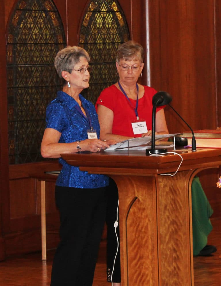 Stephanie Warren, left, and Paula Chandler Gray, both class of 1973, take turns reading the names of deceased alumnae from the past year during Mass. Stephanie is the Alumnae Association president, while Paula is the treasurer.