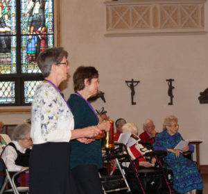 Carole Caummisar Sanders, left, and Judy Ochsner Yates, both class of 1968, present the offertory gifts during Mass.