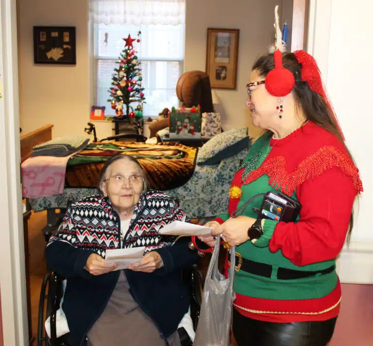 Sister Lois Lindle, left, sings along to “Jingle Bells” with Susan Montalvo-Gesser.