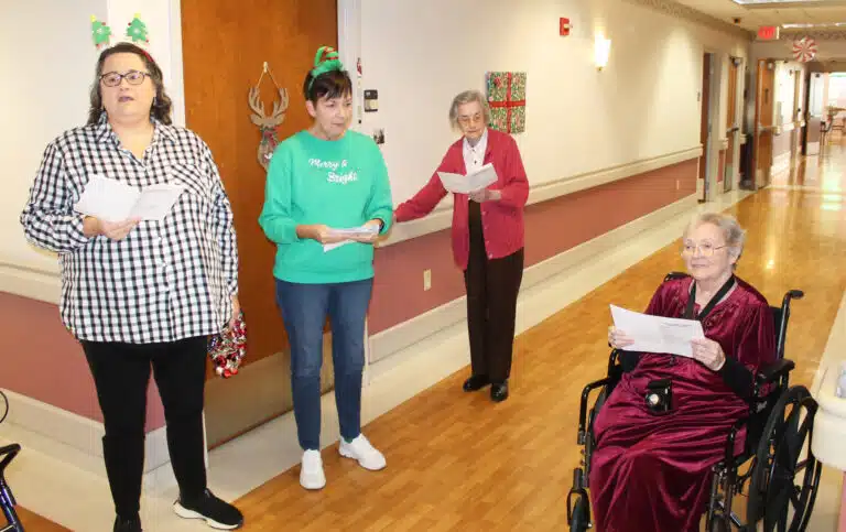 Sister Pat Rhoten, right, and Sister Mary Gerald Payne, second from right, join the caroling with Robin Tomes, left, and Patti Bartley. Tomes is an administrative assistant with the diocese and Bartley works with the Marriage Tribunal.