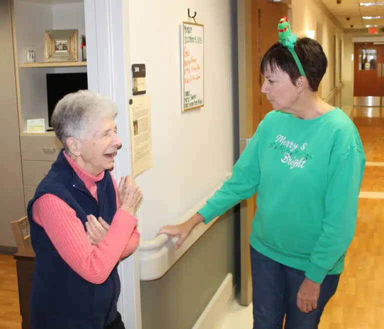 Sister Joan Riedley enjoys a laugh with Patti Bartley after the singing.