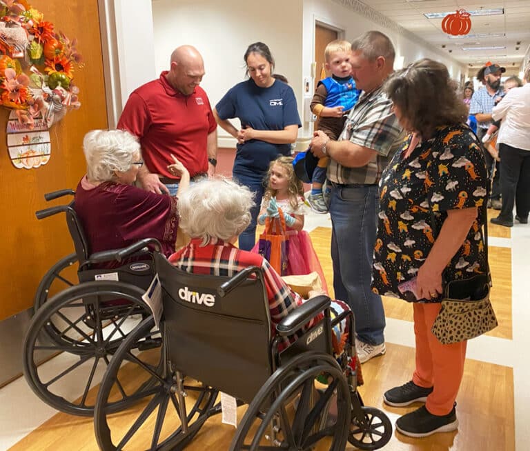 Employees Mike and Charlotte Stelmach, right, bring their grandchildren, Madison and Austin, to visit with Sister Pat Rhoten, left, and Sister Grace Swift. Their son Andrew and his wife Megan are standing at left.