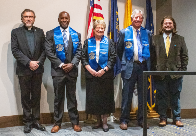 The three recipients of the Brescia Distinguished Alumni in 2022 stand next to Brescia President Father Larry Hostetter, left, and Jake Davis, right, director of Alumni and Donor Relations. The recipients from left are Keith Wells, Sister Amelia Stenger and Greg Merimee.