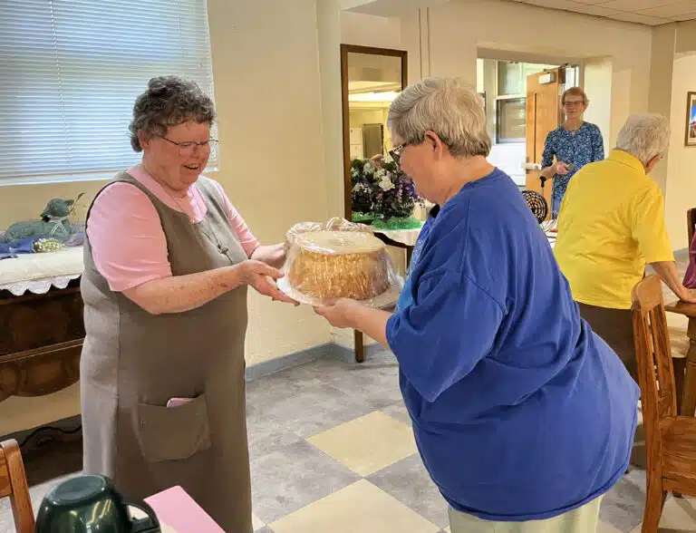Glenmary Sister Darlene Presley, left, literally “takes the cake” from Ursuline Sister Mary McDermott. Glenmary Sister Darlene Presley, left, literally “takes the cake” from Ursuline Sister Mary McDermott.