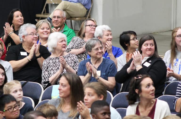 In the first row from left, Ursuline Sisters Martha Keller, Vivian Bowles, Jacinta Powers and Monica Seaton, joined by Ursuline Sister Pam Mueller behind them in the blue, clap for one of the schools being announced. All of the Sisters are former educators, with Sister Martha and Sister Monica now serving on the Ursuline Leadership Council.
