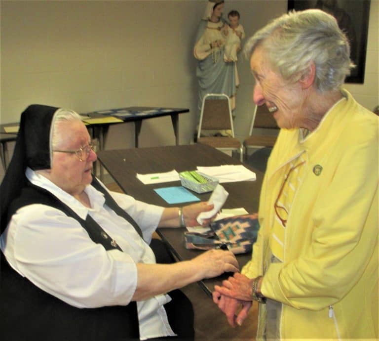 Sister Catherine Marie Lauterwasser, left, and Sister Marietta Wethington enjoy a conversation during a break. The two entered the community together in 1955.