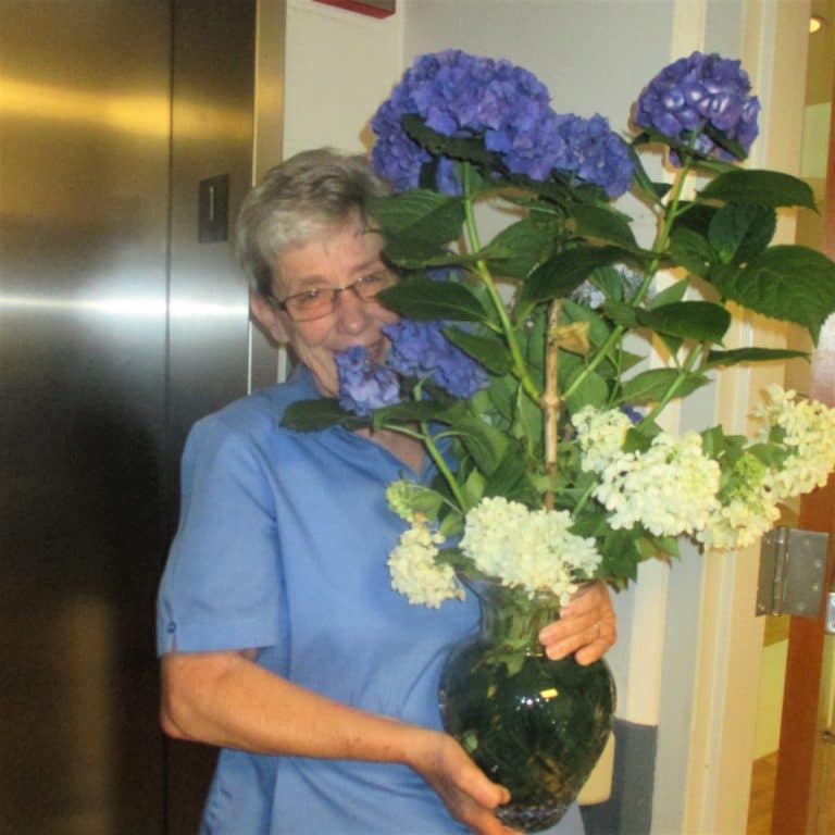 Sister Judith Nell Riney appears to be losing this battle with the flower arrangement.