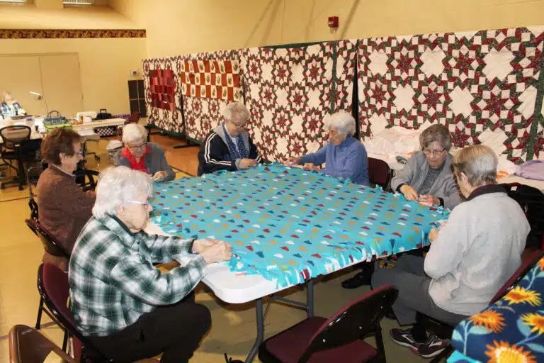 Ursuline Sisters work on making blankets which will be given to a local women’s shelter. From the front left corner going clockwise are Sisters Angela Fitzpatrick, Susan Mary Mudd, George Mary Hagan, Michele Morek, Elaine Burke, Margaret Ann Aull, and Maureen O’Neill.