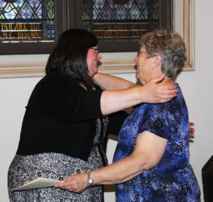 Sister Stephany gets a hug from her housemate, Sister Betsy Moyer.