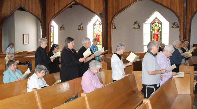 Ursuline Sisters and other sisters sing the opening hymn. From left, seated are Sister Paul Marie Greenwell, Sister Luisa Bickett and Sister Francis Louise Johnson; standing are Sister Maureen O’Neill, Sister Monica Seaton, Sister Martha Keller, Sister Ann Patrice Cecil, Sister Emma Anne Munsterman and Sister Ann McGrew.
