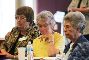 Sister Ann Patrice Cecil, center, goes over some notes from the morning session, as Sister Margaret Ann Aull, left, and Sister Nancy Murphy prepare for the afternoon session.