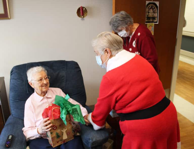 Sister Marie Bosco Wathen, left, enjoys her bag of goodies from Elaine Wood and Sid Mason. Sister Marie Bosco will celebrate 80 years as a Sister in 2023.