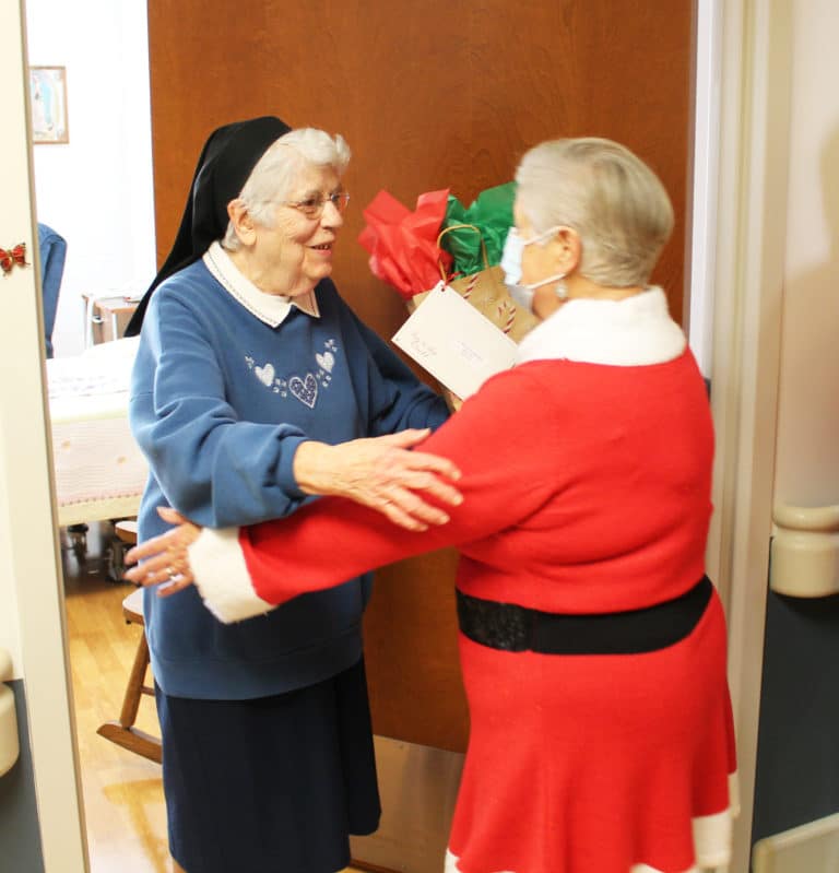 Sister Michael Ann Monaghan gets a hug and a present from Elaine Wood. She is celebrating 70 years as a Sister this year.