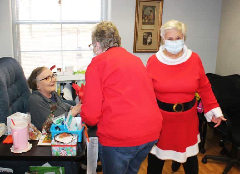 Sister Lois Lindle couldn’t believe how many presents the Associates brought her. Here she is receiving a gift from Lois Bell and Elaine Wood.