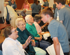 Sister Lois Lindle, left, and Sister Fran Wilhelm are all smiles while chatting with this young man. In the background is Sister Mary Jude Cecil.
