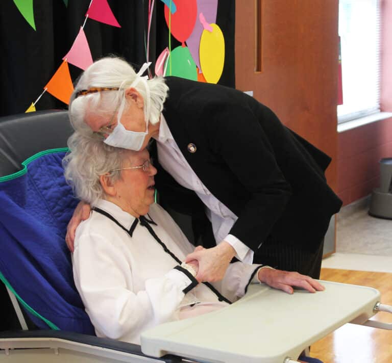 Sister Nancy Liddy gives Sister Marie a hug. Sister Nancy said later that whenever she asked Sister Marie how she was doing, she replied, “Fit as a fiddle with one string broken.”