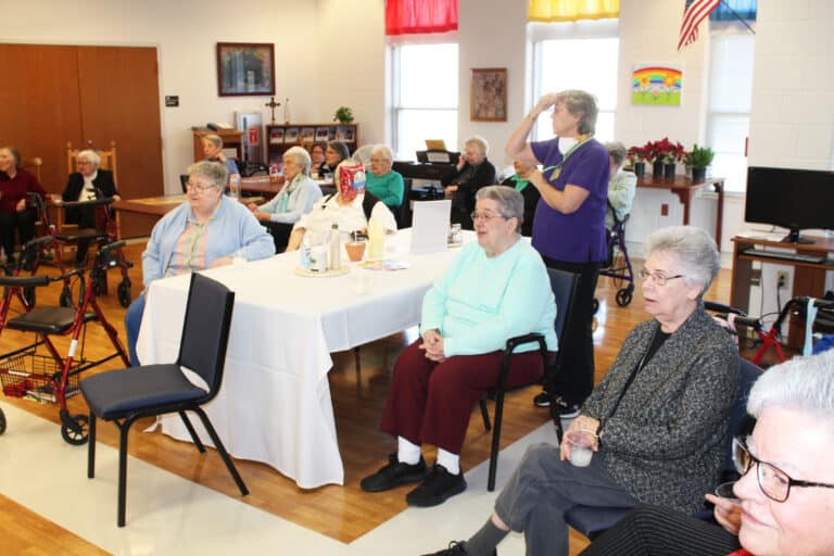 The Sisters gathered in the Rainbow Room sing along with Sister Grace.