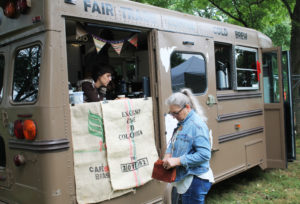 Lori Champion reaches into her purse as she prepares to buy a cup of coffee from Megan Toomey, owner of The Spot Coffee and Finery. Toomy began driving The Spot bus to events earlier this year.