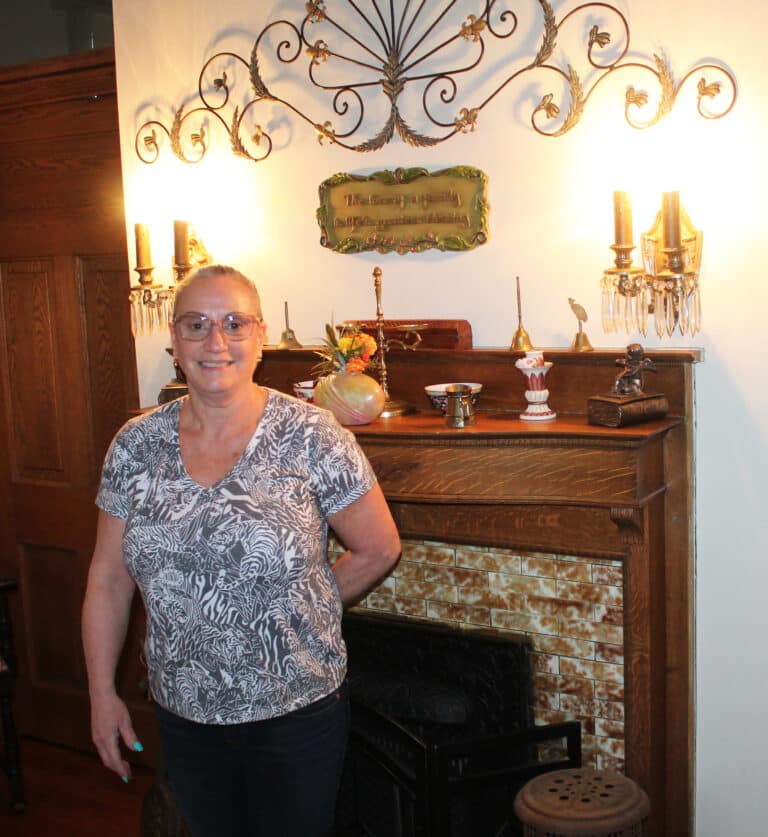 Janice Luckock stands in front of one of the fireplaces in her home at 514 St. Ann St.