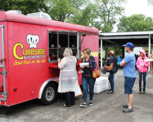 Patrons get in line for lunch at Curbside Kitchenette, one of the food vendors at the festival.