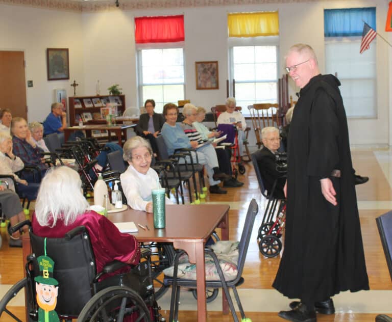 Father Godfrey Mullen laughs at something Sister Pat Rhoten said, left, as Sister Rose Karen Johnson joins in the fun.