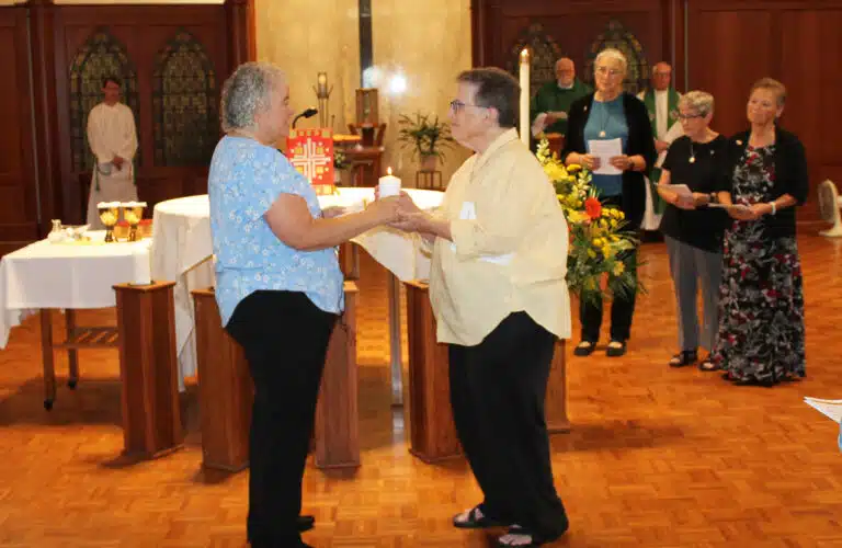 Sister Martha Keller, left, hands Sister Sharon Sullivan a candle and says, “I share with you the light of the Spirit and ask God’s blessing upon you.” Sister Martha Keller, left, hands Sister Sharon Sullivan a candle and says, “I share with you the light of the Spirit and ask God’s blessing upon you.”