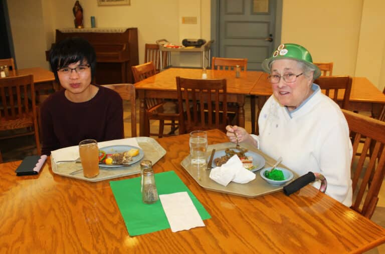 Sister Chanh Ngo, a student at Brescia University and a Sister of Our Lady of Unity of Bac Ninh, left, enjoys her meal while talking to Sister Karla Kaelin. Sister Chanh spent her spring break with the Ursuline Sisters and told them how much she enjoyed their hospitality.