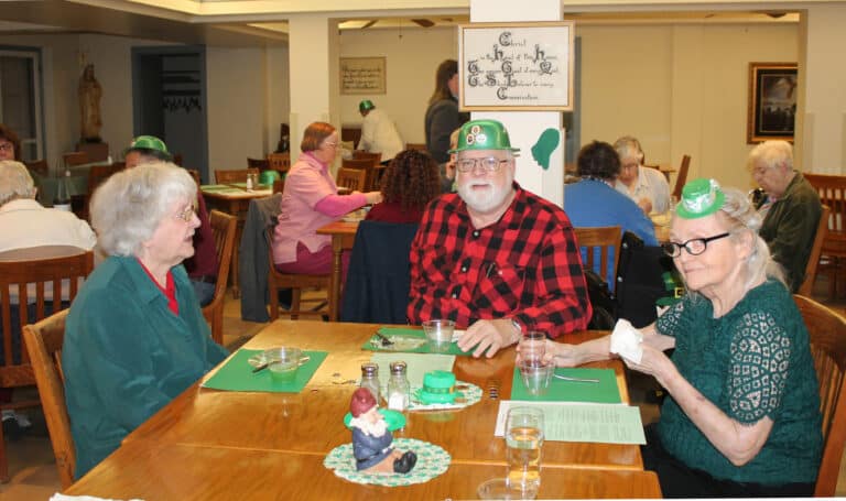 Father Ray Goetz, Motherhouse chaplain, dressed for the occasion in a green hat. He was joined by Sister Francis Louise Johnson, left, and Sister Pat Rhoten, who both wore green for the gathering.
