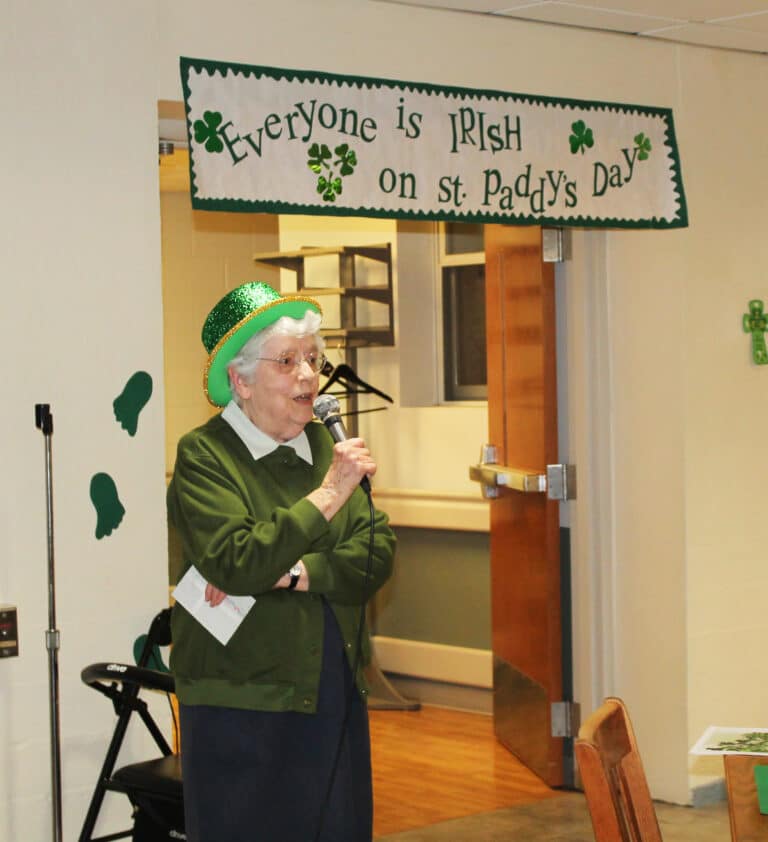 Sister Michael Ann Monaghan tells the partygoers some Irish trivia, including the fact that residents of Ireland call the country their “homeland.” Sister Elaine Burke made the sign hanging over the entranceway.