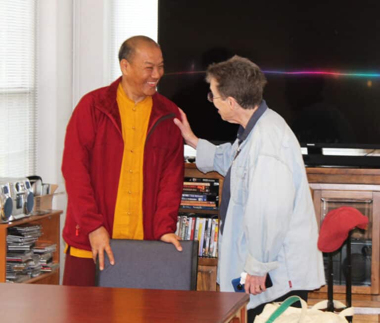 Sister Sharon Sullivan, congregational leader for the Ursuline Sisters, greets Venerable Tsering Phuntsok, a Tibetan Buddhist monk from Nepal, shortly after his arrival in the Rainbow Room on March 23, 2023.