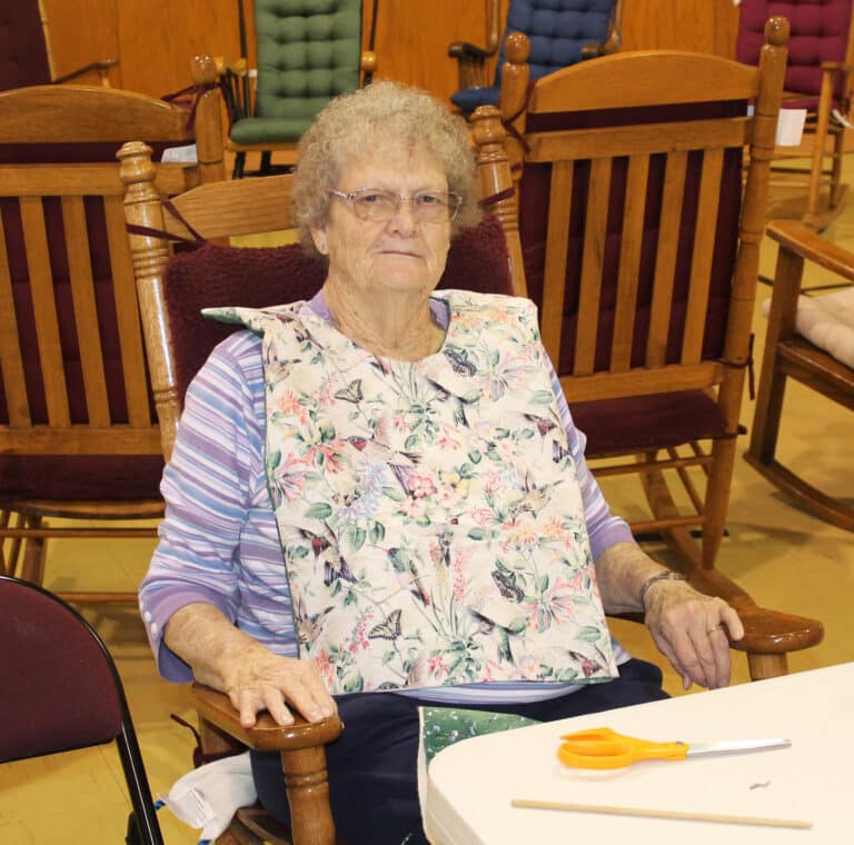 Ursuline Associate Mary Teder models one of the aprons her daughter Ann Jacobs made for the Sisters in Saint Joseph Villa.