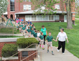 Sister Amelia leads the children across campus on the pretty spring day. Behind her in the green shirt is Sister Laurita Spalding.