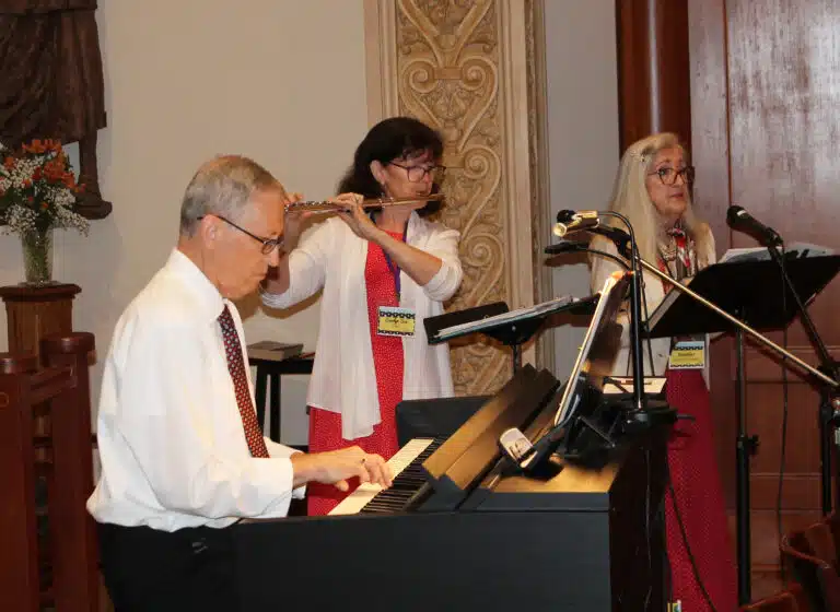 Brett Ballard plays the piano as Carolyn Sue Cecil A’73 plays the flute and Jennifer Speaks McGee A’70 cantors during the opening hymn “Gather the People.” Brett Ballard plays the piano as Carolyn Sue Cecil A’73 plays the flute and Jennifer Speaks McGee A’70 cantors during the opening hymn “Gather the People.”