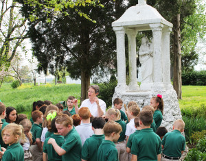 Gathered before the statue of Our Lady of Prompt Succor, Sister Amelia shows the students two different types of lavender.