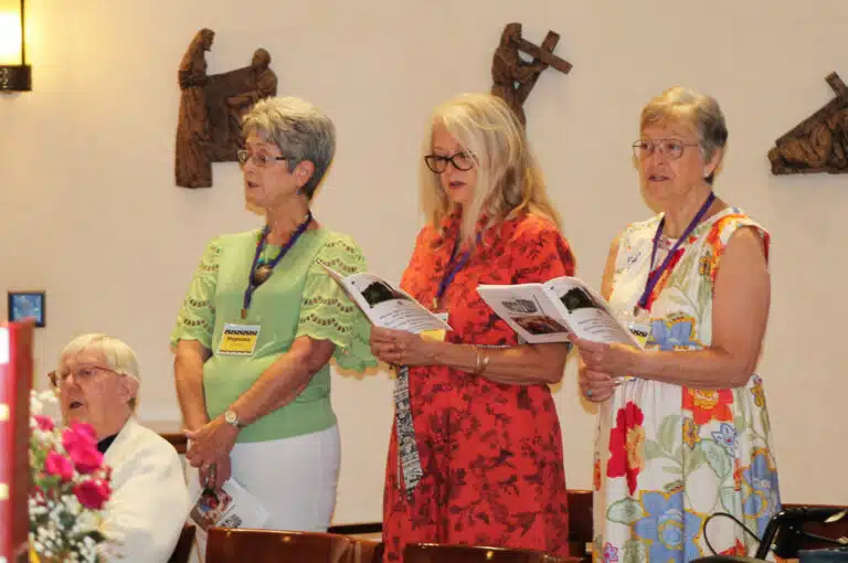 Classmates from 1973 Stephanie Warren, standing left, Rhonda Warren Mischel and Paula Chandler Gray join Sister Grace Simpson in singing the opening hymn. Classmates from 1973 Stephanie Warren, standing left, Rhonda Warren Mischel and Paula Chandler Gray join Sister Grace Simpson in singing the opening hymn.