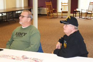 Jim Likens, left, served in the U.S. Army beginning in 1970 in Korea, while Marvin Clark served in the Army in Germany from 1962-65. Here they listen to Father Dolan talk about the need to listen to those serving in the military to ease the pressure that builds inside them.
